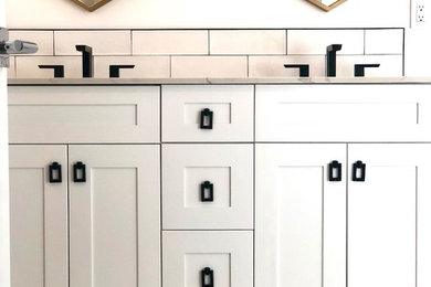 Example of an eclectic master white tile and subway tile porcelain tile and black floor bathroom design in Miami with recessed-panel cabinets, white cabinets, a one-piece toilet, white walls, an undermount sink, tile countertops and beige countertops