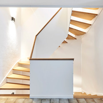 Treppe aus weißem HPL mit Handläufen und Stufen aus Eiche