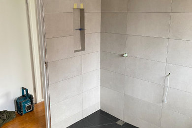 This is an example of a modern master bathroom with gray tile and porcelain tile.