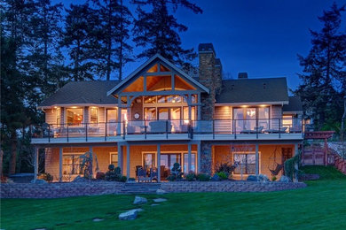 Large rustic brown two-story mixed siding exterior home idea in Seattle with a shingle roof