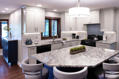 Inspiration for a medium sized classic l-shaped enclosed kitchen in Indianapolis with a submerged sink, recessed-panel cabinets, beige cabinets, granite worktops, blue splashback, ceramic splashback, black appliances, dark hardwood flooring, an island, brown floors and beige worktops.