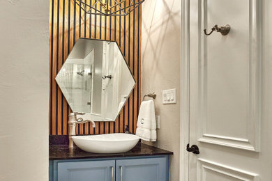 Inspiration for a small contemporary shower room bathroom in Dallas with freestanding cabinets, blue cabinets, an alcove shower, a two-piece toilet, beige walls, marble flooring, a vessel sink, marble worktops, grey floors, a hinged door, black worktops, a single sink and a built in vanity unit.