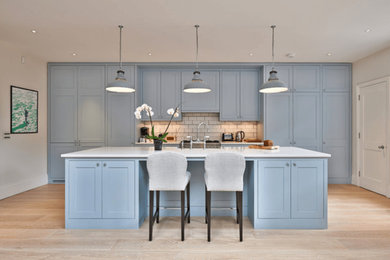 Inspiration for a mid-sized transitional galley open plan kitchen in Other with a double-bowl sink, raised-panel cabinets, blue cabinets, green splashback, ceramic splashback, vinyl floors, with island, quartz benchtops, coloured appliances and beige floor.