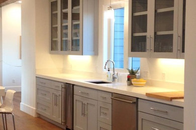 Eat-in kitchen - small contemporary single-wall light wood floor and brown floor eat-in kitchen idea in Denver with an undermount sink, glass-front cabinets, white cabinets, quartzite countertops, stainless steel appliances and white backsplash