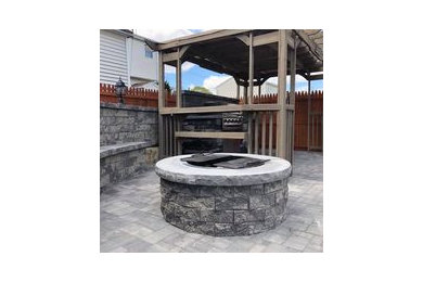 Patio - large modern backyard brick patio idea in Providence with a fire pit and a pergola