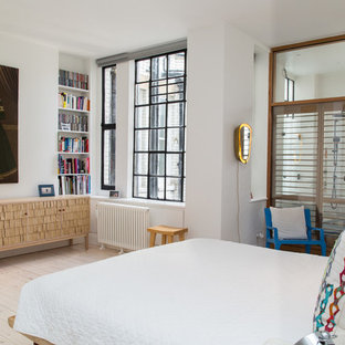 Mediterranean master bedroom in London with white walls, light hardwood flooring and beige floors.