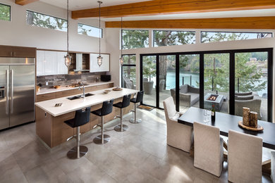 This is an example of a mid-sized modern l-shaped eat-in kitchen with an undermount sink, medium wood cabinets, multi-coloured splashback, stainless steel appliances and with island.