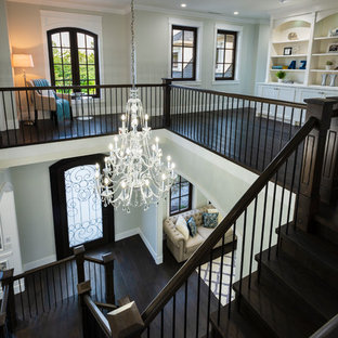 Foto på en mycket stor vintage hall, med vita väggar, mörkt trägolv och svart golv