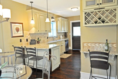 Eat-in kitchen - mid-sized traditional l-shaped dark wood floor eat-in kitchen idea in Minneapolis with an undermount sink, raised-panel cabinets, white cabinets, granite countertops, beige backsplash, porcelain backsplash, stainless steel appliances and a peninsula