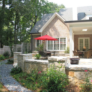 Design ideas for a mid-sized traditional backyard verandah in Atlanta with natural stone pavers and a roof extension.