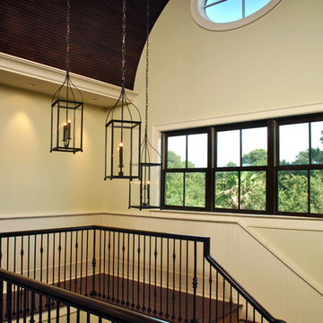 Trio of chandeliers at different heights adds interest to stairway