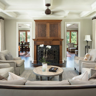 Design ideas for a mid-sized traditional enclosed family room in Charleston with grey walls, dark hardwood floors, a standard fireplace, a concealed tv, a wood fireplace surround and brown floor.