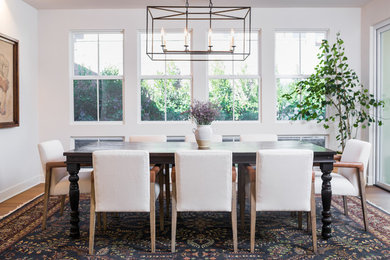 Country dining room in San Diego with white walls, medium hardwood floors and no fireplace.