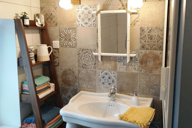 Exemple d'une salle de bain rétro avec une douche ouverte, WC suspendus, un carrelage multicolore, des carreaux de béton, un mur bleu, carreaux de ciment au sol, un lavabo de ferme, un sol multicolore et meuble simple vasque.