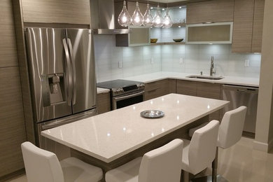Design ideas for a small modern l-shaped open plan kitchen in Miami with an undermount sink, flat-panel cabinets, grey cabinets, quartz benchtops, white splashback, glass tile splashback, stainless steel appliances, porcelain floors and with island.