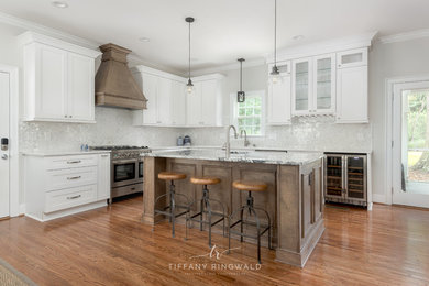 Large cottage l-shaped medium tone wood floor eat-in kitchen photo in Charlotte with shaker cabinets, white cabinets, granite countertops, white backsplash, mosaic tile backsplash, stainless steel appliances and an island