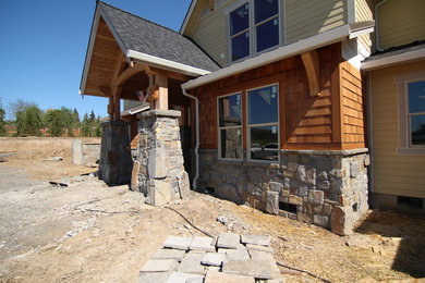 Inspiration for a huge craftsman yellow two-story stone exterior home remodel in Portland