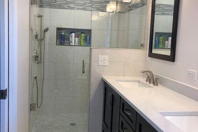 Inspiration for a contemporary master white tile and porcelain tile porcelain tile and gray floor alcove shower remodel in Charlotte with shaker cabinets, dark wood cabinets, a two-piece toilet, an undermount sink, quartz countertops and white countertops