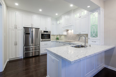 Inspiration for a mid-sized transitional u-shaped dark wood floor and brown floor eat-in kitchen remodel in Toronto with an undermount sink, raised-panel cabinets, white cabinets, quartz countertops, multicolored backsplash, stone tile backsplash, stainless steel appliances and a peninsula