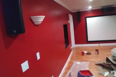 Diseño de cine en casa cerrado moderno con paredes rojas y pantalla de proyección