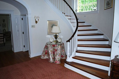Ejemplo de escalera curva de tamaño medio con escalones de madera y contrahuellas de madera pintada