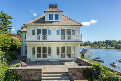 Large elegant white three-story wood exterior home photo in Other with a hip roof