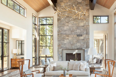 Example of a large mountain style open concept light wood floor and wood ceiling living room design in Sacramento with beige walls, a standard fireplace and a stone fireplace