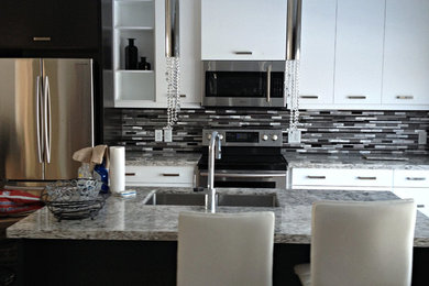 Large trendy light wood floor kitchen photo in Toronto with an undermount sink, flat-panel cabinets, white cabinets, granite countertops, metallic backsplash, matchstick tile backsplash, stainless steel appliances and an island