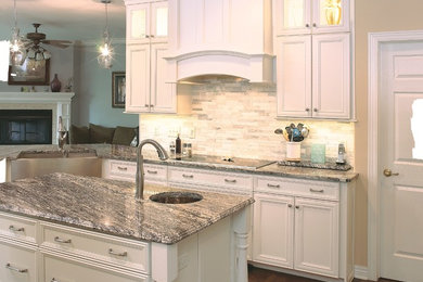 Open concept kitchen - mid-sized traditional u-shaped dark wood floor open concept kitchen idea in Nashville with an island, beaded inset cabinets, white cabinets, granite countertops, white backsplash, stone tile backsplash, stainless steel appliances and a farmhouse sink