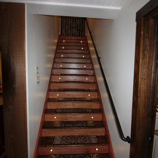 他の地域の中サイズのカントリー風おしゃれな地下室 (半地下 (ドアあり)、ベージュの壁、ラミネートの床、薪ストーブ、茶色い床) の写真