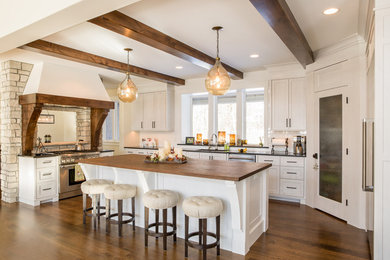Large cottage chic u-shaped dark wood floor eat-in kitchen photo in Minneapolis with an undermount sink, shaker cabinets, white cabinets, wood countertops, white backsplash, subway tile backsplash, stainless steel appliances and an island