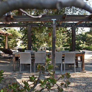 Mediterranean patio in Santa Barbara with gravel and a pergola.