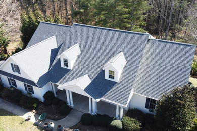Modelo de fachada de casa blanca y gris contemporánea grande de dos plantas con revestimiento de aglomerado de cemento, tejado a dos aguas y tejado de teja de madera