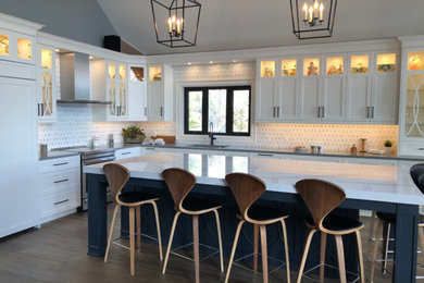 Example of a large beach style l-shaped medium tone wood floor and brown floor eat-in kitchen design in Toronto with an undermount sink, shaker cabinets, white cabinets, quartz countertops, white backsplash, marble backsplash, paneled appliances, an island and white countertops