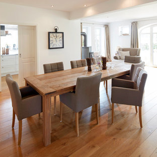 ブレーメンの広いカントリー風 LDKの画像 (白い壁、無垢フローリング、薪ストーブ、茶色い床)