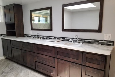 Mid-sized trendy master white tile and ceramic tile ceramic tile alcove shower photo in Salt Lake City with shaker cabinets, dark wood cabinets, white walls, an undermount sink and marble countertops