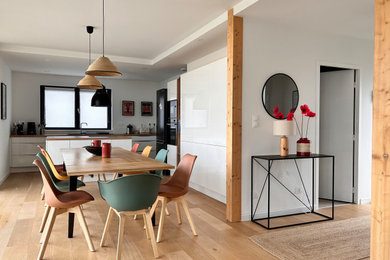 Exemple d'une salle à manger ouverte sur le salon bord de mer de taille moyenne avec un mur blanc, parquet clair et un sol beige.