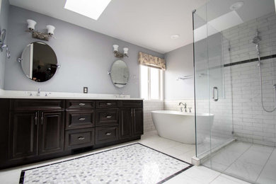 Example of a large classic master black and white tile and marble tile ceramic tile, multicolored floor and double-sink bathroom design in Seattle with raised-panel cabinets, black cabinets, a two-piece toilet, blue walls, an undermount sink, quartz countertops, a hinged shower door, white countertops, a niche and a built-in vanity