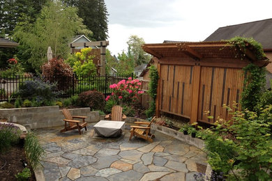 This is an example of a mid-sized arts and crafts backyard patio in Portland with natural stone pavers and a vegetable garden.