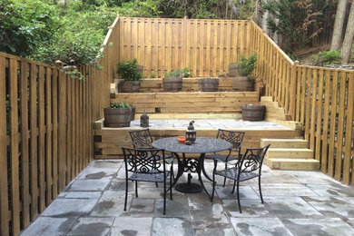 Inspiration for a mid-sized eclectic backyard stone patio remodel in Orange County with no cover
