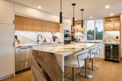 Kitchen - contemporary l-shaped medium tone wood floor and brown floor kitchen idea in Vancouver with an undermount sink, flat-panel cabinets, white cabinets, gray backsplash, stainless steel appliances, an island and gray countertops
