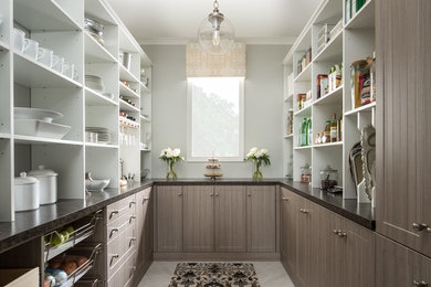 Inspiration for a mid-sized country u-shaped kitchen pantry in Chicago with grey floor, flat-panel cabinets, medium wood cabinets, solid surface benchtops, porcelain floors and no island.