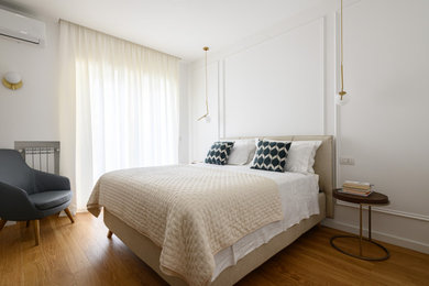 Ispirazione per una camera da letto minimal di medie dimensioni con pareti bianche, parquet chiaro e boiserie