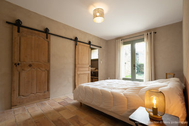 Eclectic bedroom in Montpellier with terracotta flooring.