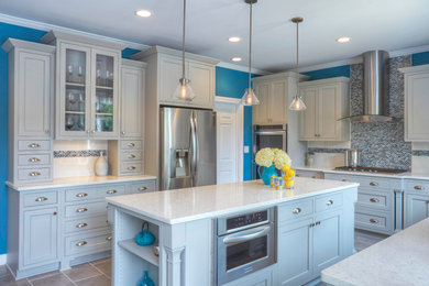 Example of a large trendy u-shaped porcelain tile and brown floor kitchen design in Chicago with an undermount sink, shaker cabinets, white cabinets, quartzite countertops, multicolored backsplash, matchstick tile backsplash, stainless steel appliances and an island