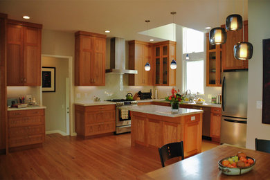 Eat-in kitchen - transitional medium tone wood floor eat-in kitchen idea in San Francisco with an undermount sink, shaker cabinets, medium tone wood cabinets, quartz countertops, white backsplash, ceramic backsplash, stainless steel appliances and an island