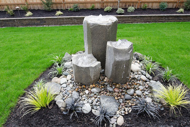 Design ideas for a huge full sun backyard concrete paver landscaping in Portland for winter.