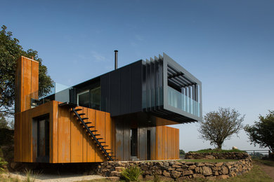 Inspiration for a contemporary two floor house exterior in London with metal cladding and a flat roof.