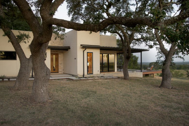 Example of a mid-sized trendy beige one-story mixed siding exterior home design in Austin with a metal roof