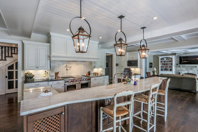 Inspiration for a mid-sized timeless galley dark wood floor open concept kitchen remodel in Chicago with raised-panel cabinets, white cabinets, marble countertops, white backsplash, subway tile backsplash, stainless steel appliances and an island